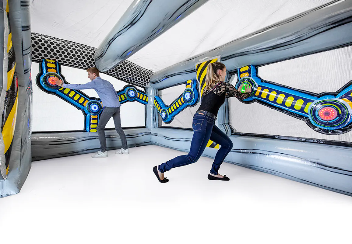 Two adults racing to press illuminated targets inside the IPS Bunker