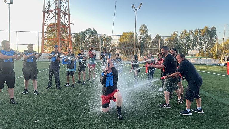 Teams competing with water blasters on an outdoor field