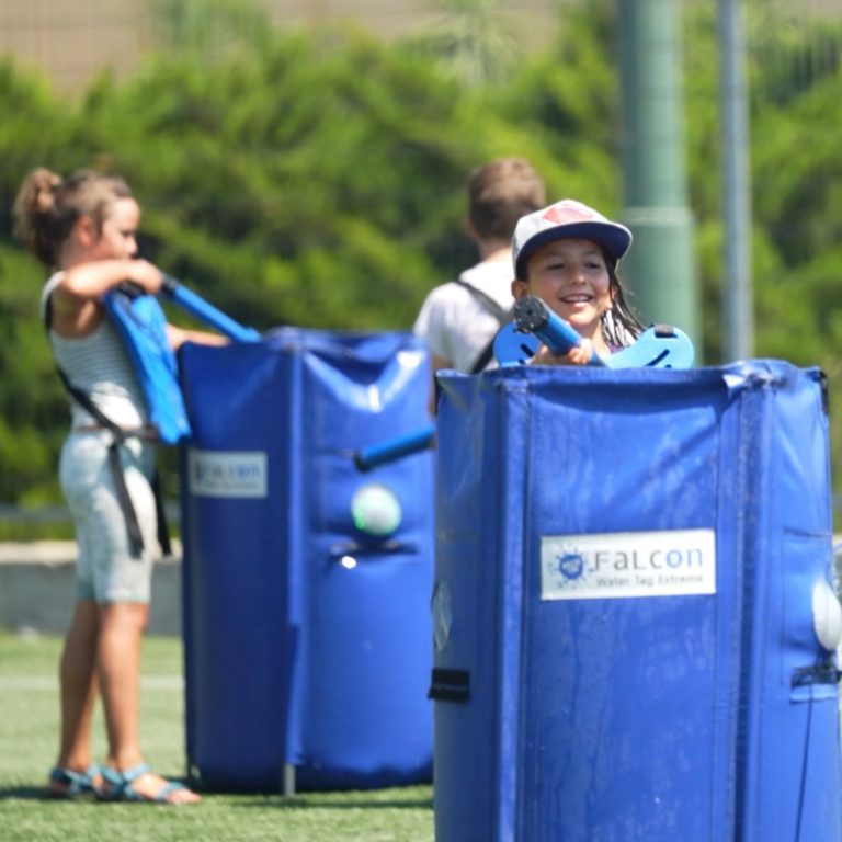 Young participant smiling behind a blue Water Tag barrier