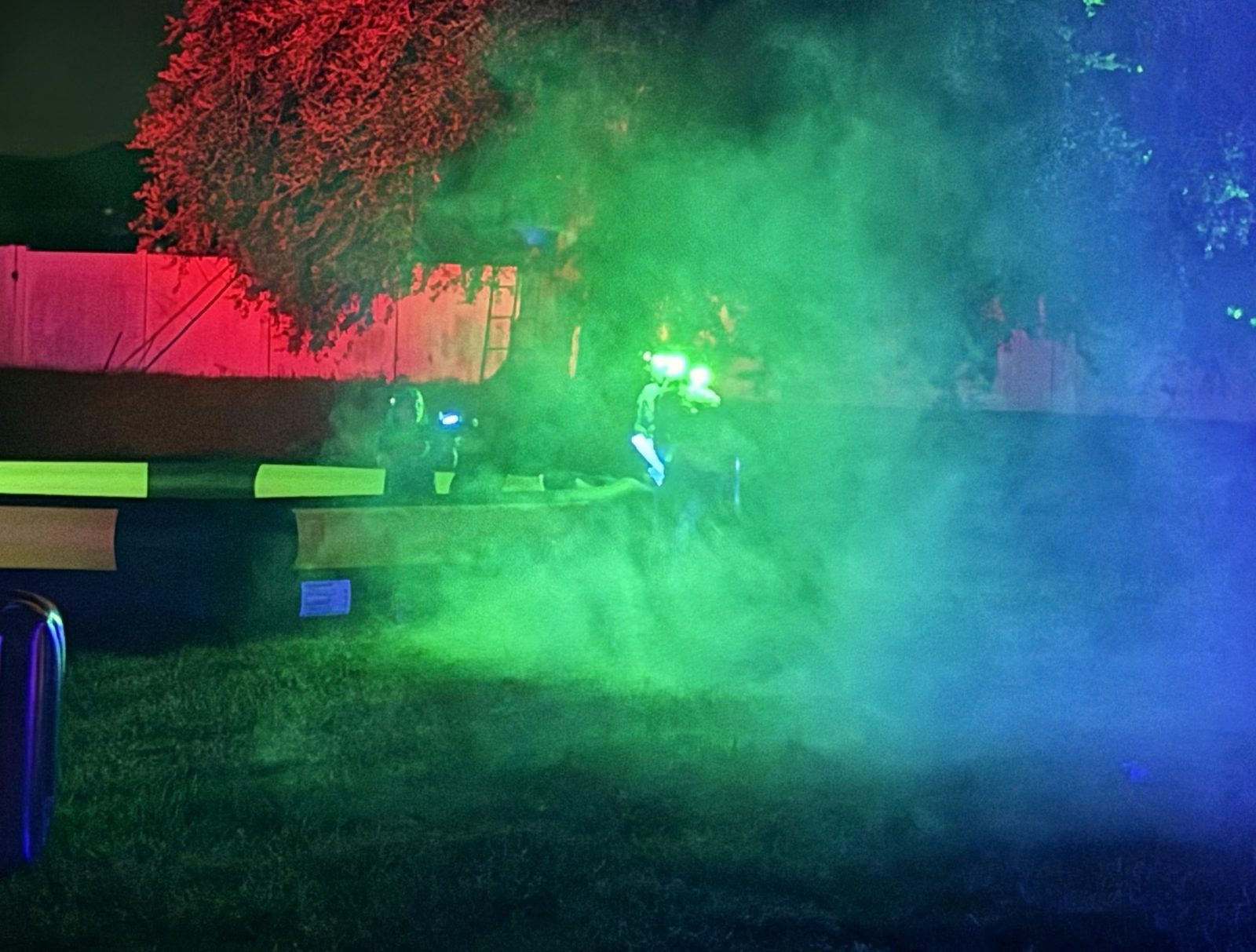 Players moving through green and blue fog during a nighttime laser-tag game